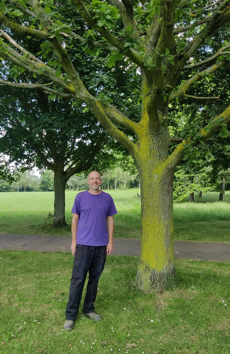 Mark standing beneath the oak tree
